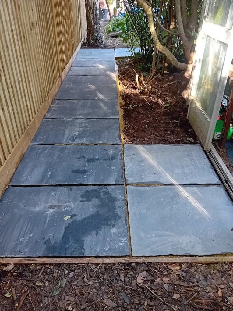 Slate garden pathway installation with neatly aligned slabs, improving garden access with durable hard-landscaping.